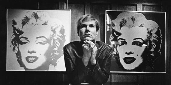 Abbildung zu: Andy Warhol vor zwei Gemälden der Marilyn-Serie, Foto: Donald Getsug. © The Andy Warhol Foundation for the Visual Arts