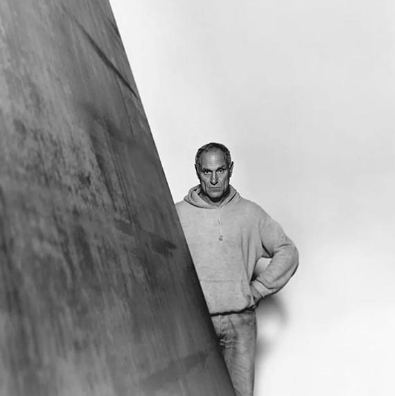Abbildung zu: Richard Serra neben einer seiner Arbeiten, Foto: unbekannt. &copy; Estate of Richard Serra / VG Bild-Kunst, Bonn 2026